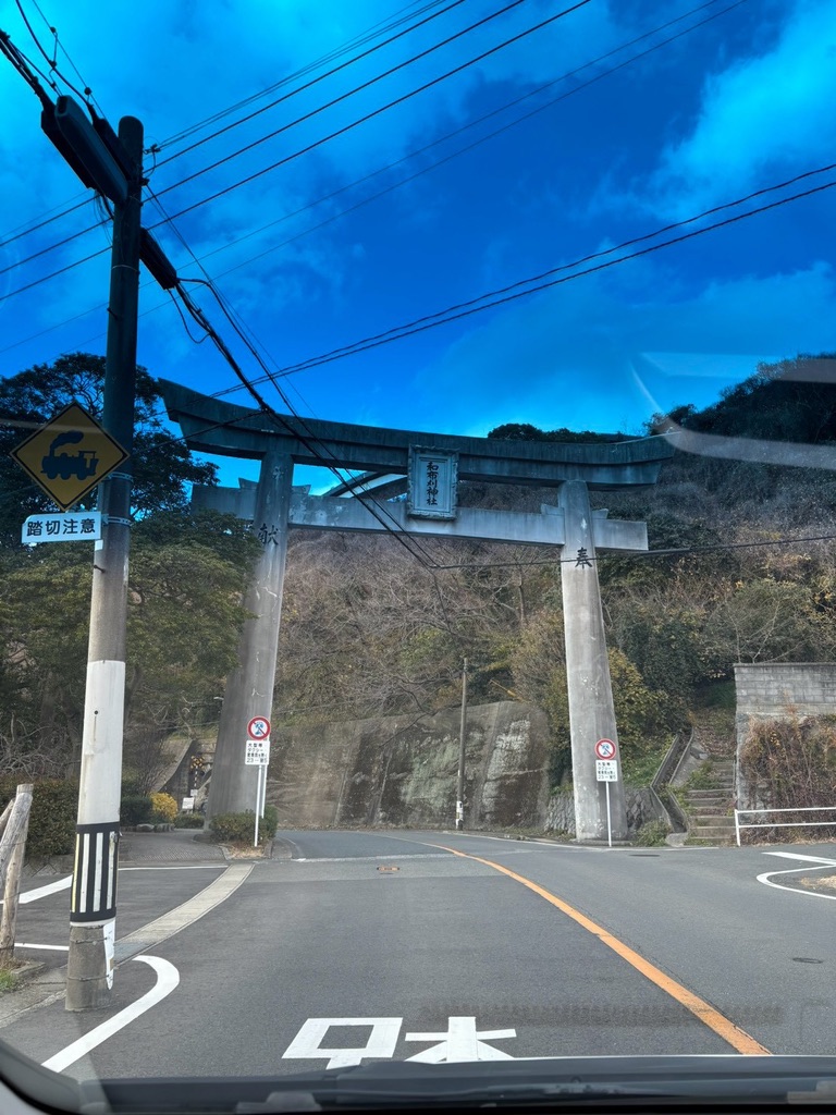 道路をまたぐように立つ和布刈神社の大きな石鳥居。扁額に「和布刈神社」の文字
