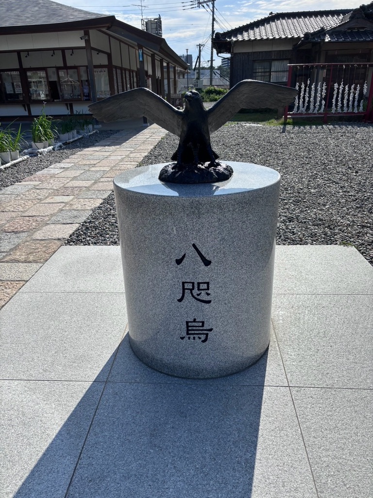 岡田宮の境内に立つ、翼を広げた八咫烏の銅像。台座に「八咫烏」と刻まれている